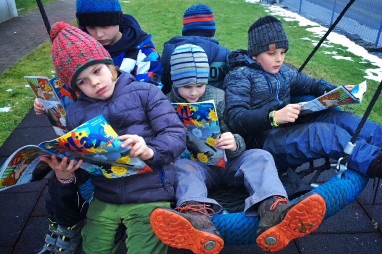 Mehrere Kinder lesen das Magazin KLÄX im Rahmen der Jungscharlese-Aktion.