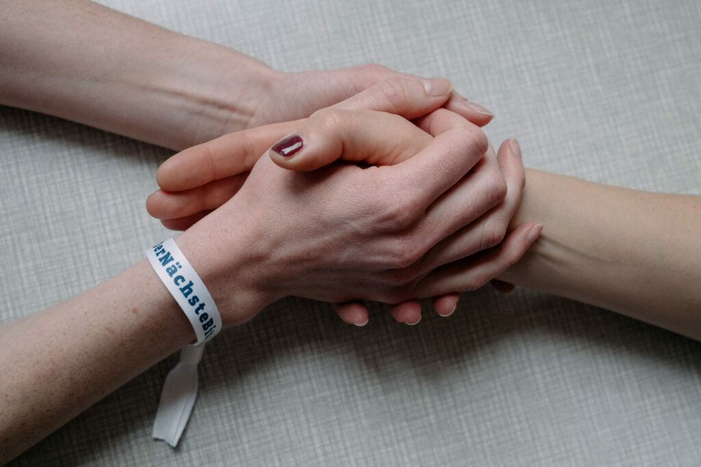 Zwei Hände mit dem Armband #DerNächsteBitte