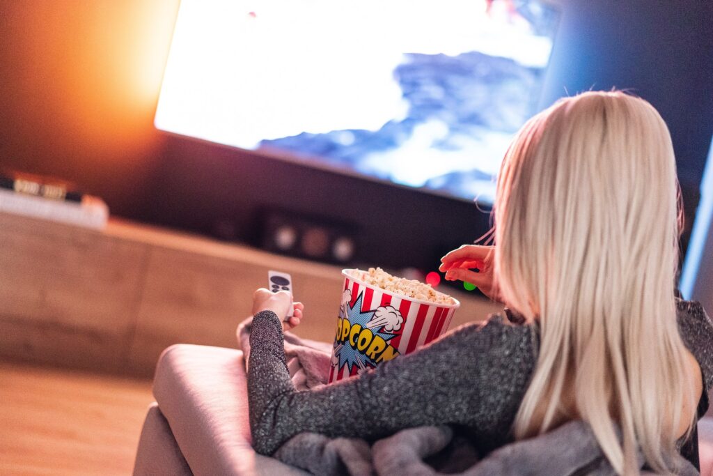 Mädchden mit Popcorn vor Fernseher